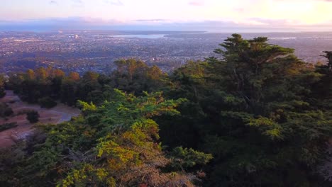 increíble puesta de sol con bosque natural y ciudad abajo en el valle, brillantes colores de puesta de sol y profundidad