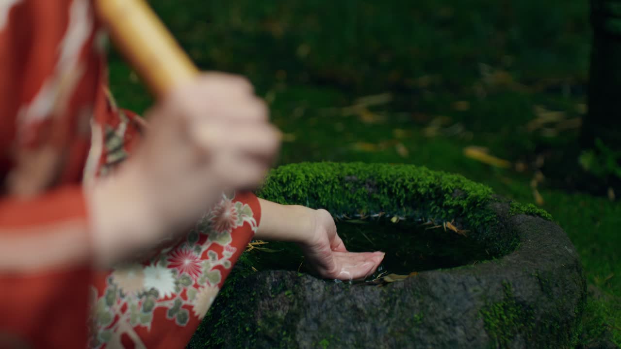Woman in Kimono Interacting with a Zen Garden