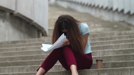 donna d'affari che guarda cattive statistiche finanziarie. il manager seduto sulle scale