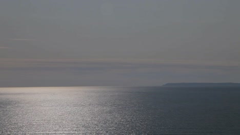 Toma-Panorámica-De-La-Isla-Lundy-Desde-La-Bahía-De-Woolacombe-Con-El-Sol-Reflejado-En-El-Mar