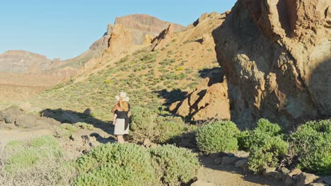 joven madre con un niño en las manos caminando por el paisaje montañoso de tenerife