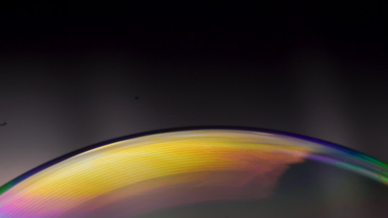 Observe soap bubbles bursting with vivid colors, offering a hypnotic display resembling a cosmic light show.