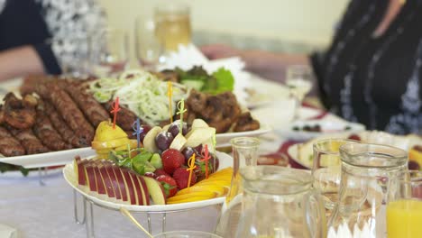 festive dinner table with delicious meal lula kebab and fruit platter.