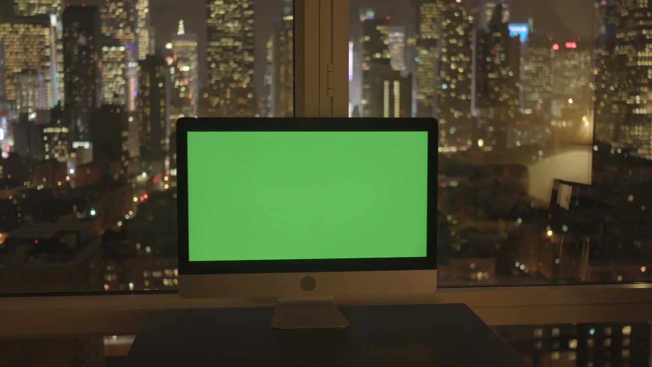 Computer with Greenscreen in Modern Office Building with Cityscape Background.