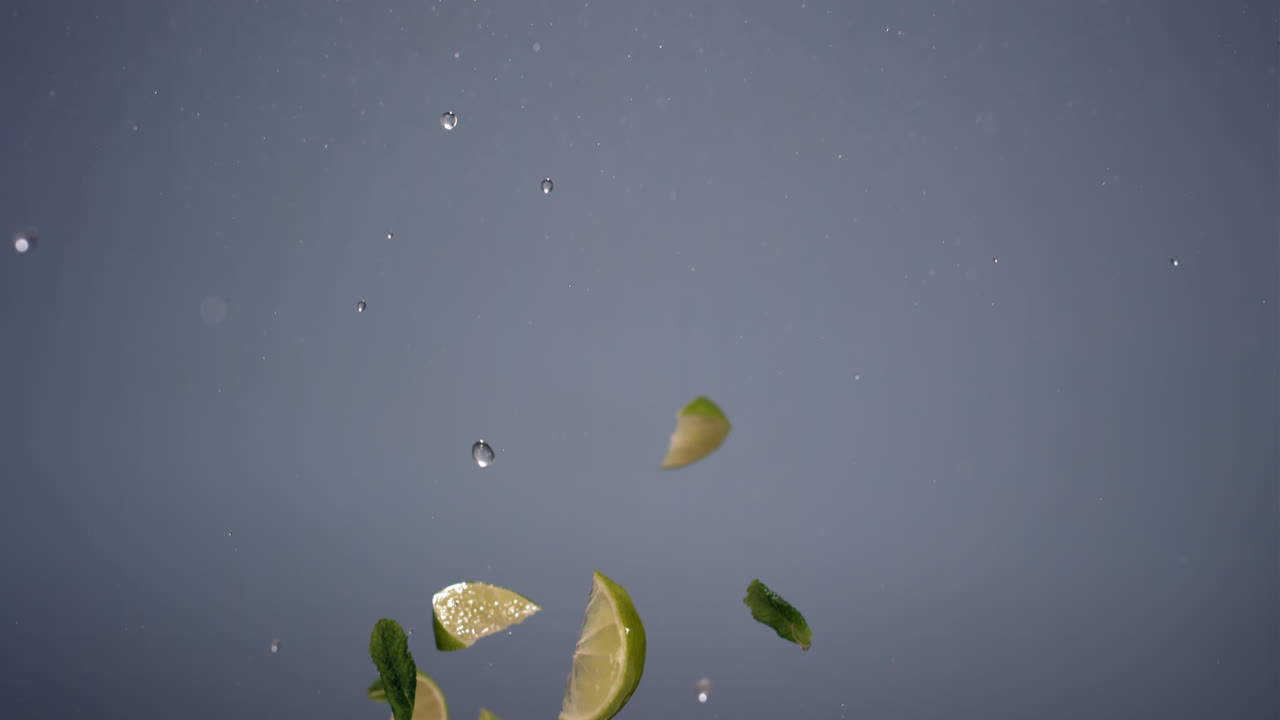 신선하게 잘라진 라임과 오렌지의 슈퍼 슬로우 모션 은 밝은 배경에 날아가는 민트 잎과 함께 고속 비디오 카메라, 420fps로 촬영되었습니다.