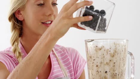 woman preparing smoothie against white background