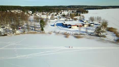 dos personas esquiando en un lago congelado en un día frío y soleado