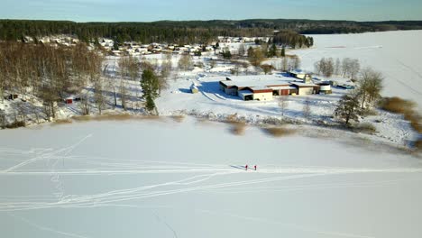 two people skiing on a frozen lake on a cold sunny day