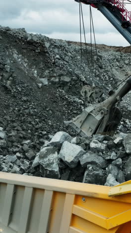 large excavator loading rocks into a dump truck at a mine site