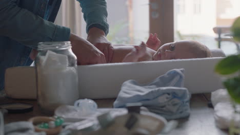 young mother changing baby diaper at home lying infant on table loving mom enjoying motherhood caring for newborn