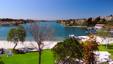 aerial drone rising through trees and flowers over community lake mission viejo