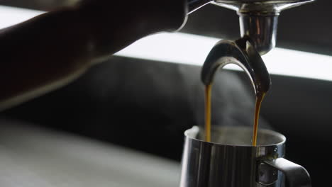 espresso being poured into a pitcher