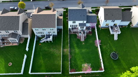 rear exterior backyard view with white picket fence and dog yard to play in green grass for pets and children