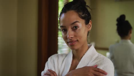 portrait of relaxed biracial woman in robe looking at camera