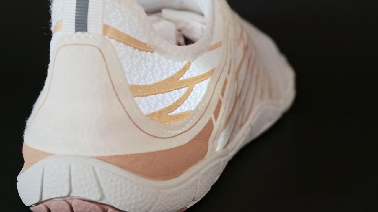 A brand new white training shoe showing details