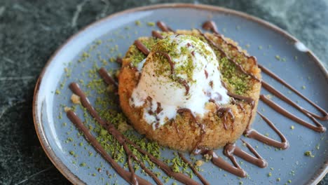 kunefe turco con helado, pistachos y jarabe de chocolate