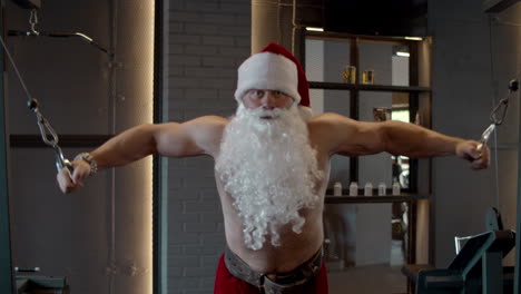 Hübscher-Weihnachtsmann,-Der-Im-Fitnessstudio-Bizepscurls-Macht.-Sportlertraining-Im-Sportverein