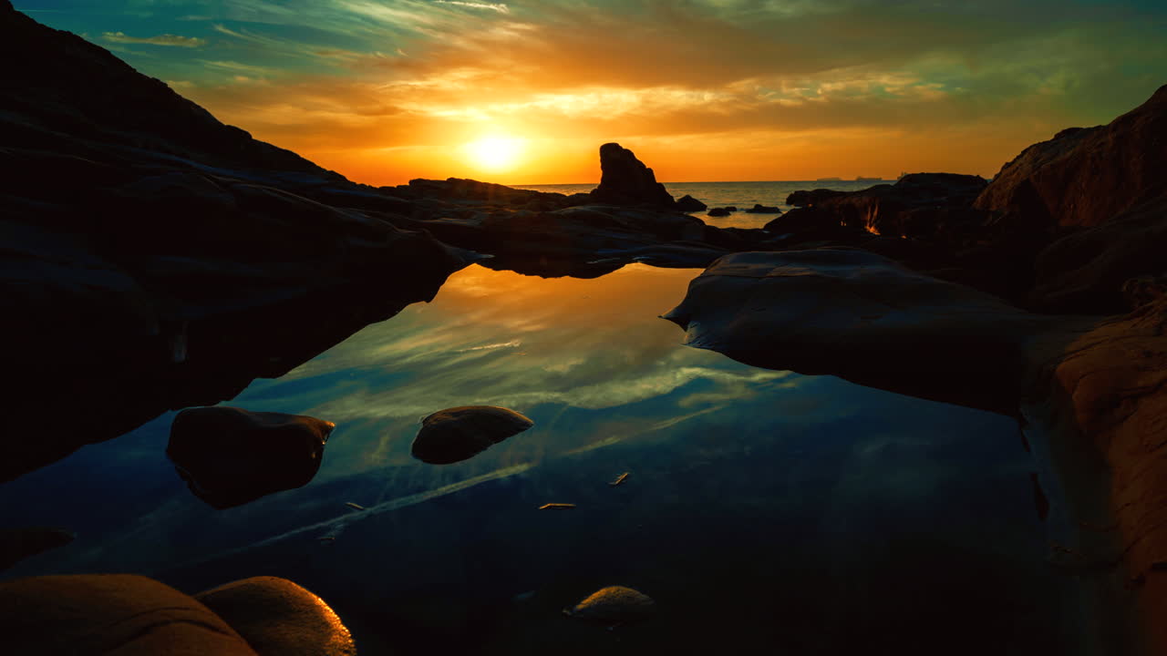 Time lapse del sole che tramonta sull'oceano con nuvole meravigliose che catturano la luce