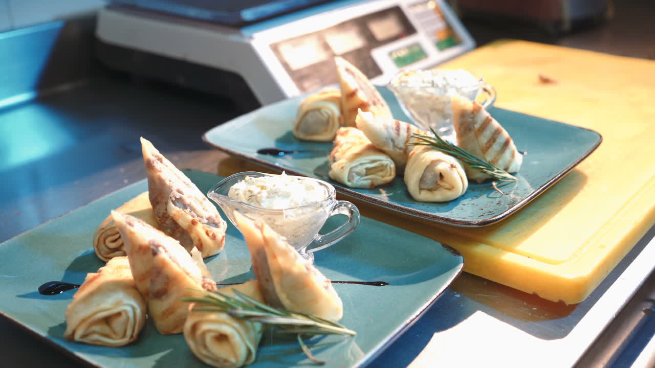 Professional chef garnishing a dish. Thin pancakes with fillings. Ready for service to the customer.