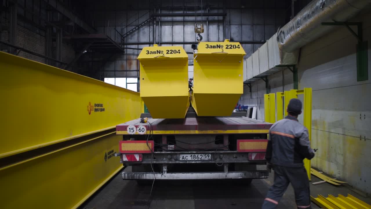 carga de equipos pesados en un camión en un entorno de fábrica