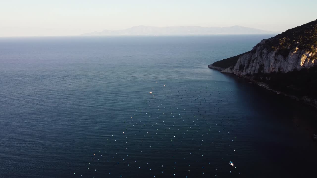 Aerial establishing shot over mussel farms, ocean farming in the Mediterranean