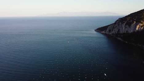 aerial establishing shot over mussel farms, ocean farming in the mediterranean