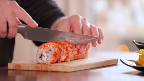 hacer sushi en la cocina de casa. manos de mujer enrollando sushi casero.