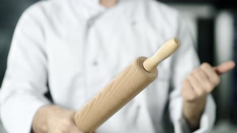 Chef-hands-rolling-roller-at-kitchen.-Closeup-chef-hands-playing-with-roller.