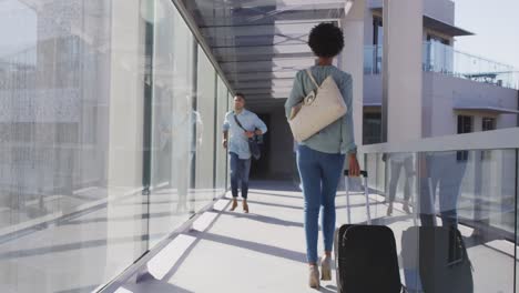 video of diverse businessman and businesswoman walking with suitcase