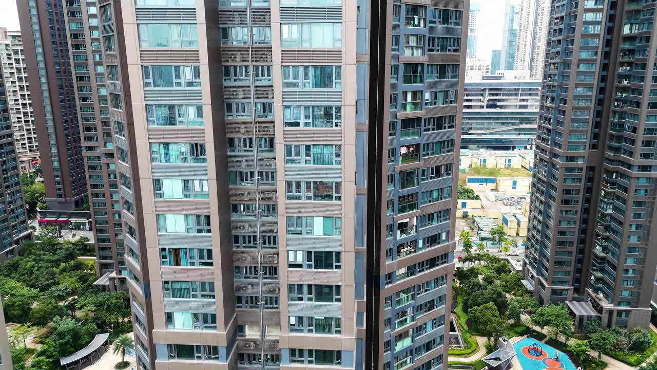 Aerial shot showcasing modern residential towers in Shenzhen, surrounded by lush green spaces and urban infrastructure. Captures urban living in China.