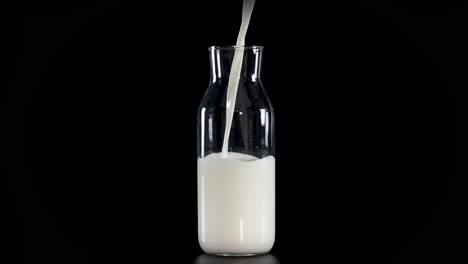 milk being poured into a glass bottle