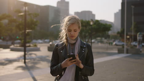 Retrato-En-Cámara-Lenta-De-Una-Linda-Joven-Rubia-Enviando-Mensajes-De-Texto-Navegando-Usando-Una-Aplicación-De-Redes-Sociales-Para-Teléfonos-Inteligentes-En-El-Fondo-Urbano-De-La-Ciudad