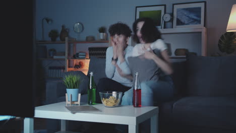 two women watching a tv show at night