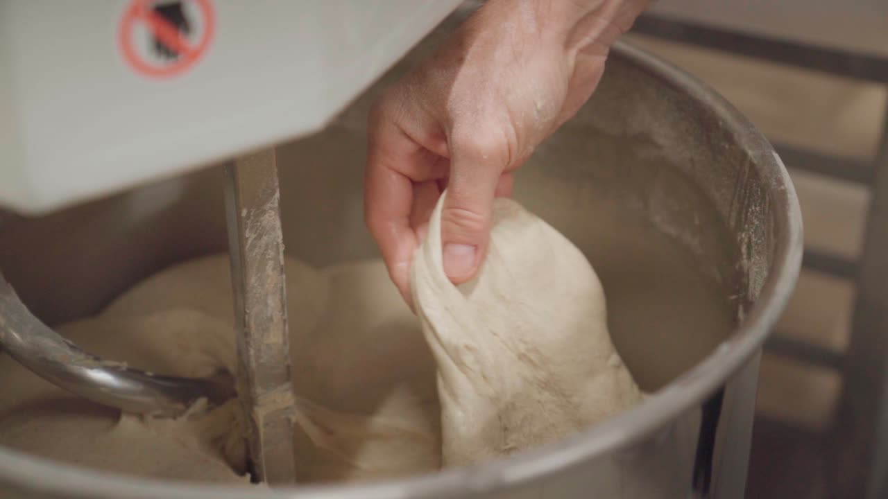 Chef checking viscosity of a dough in an electric mixer