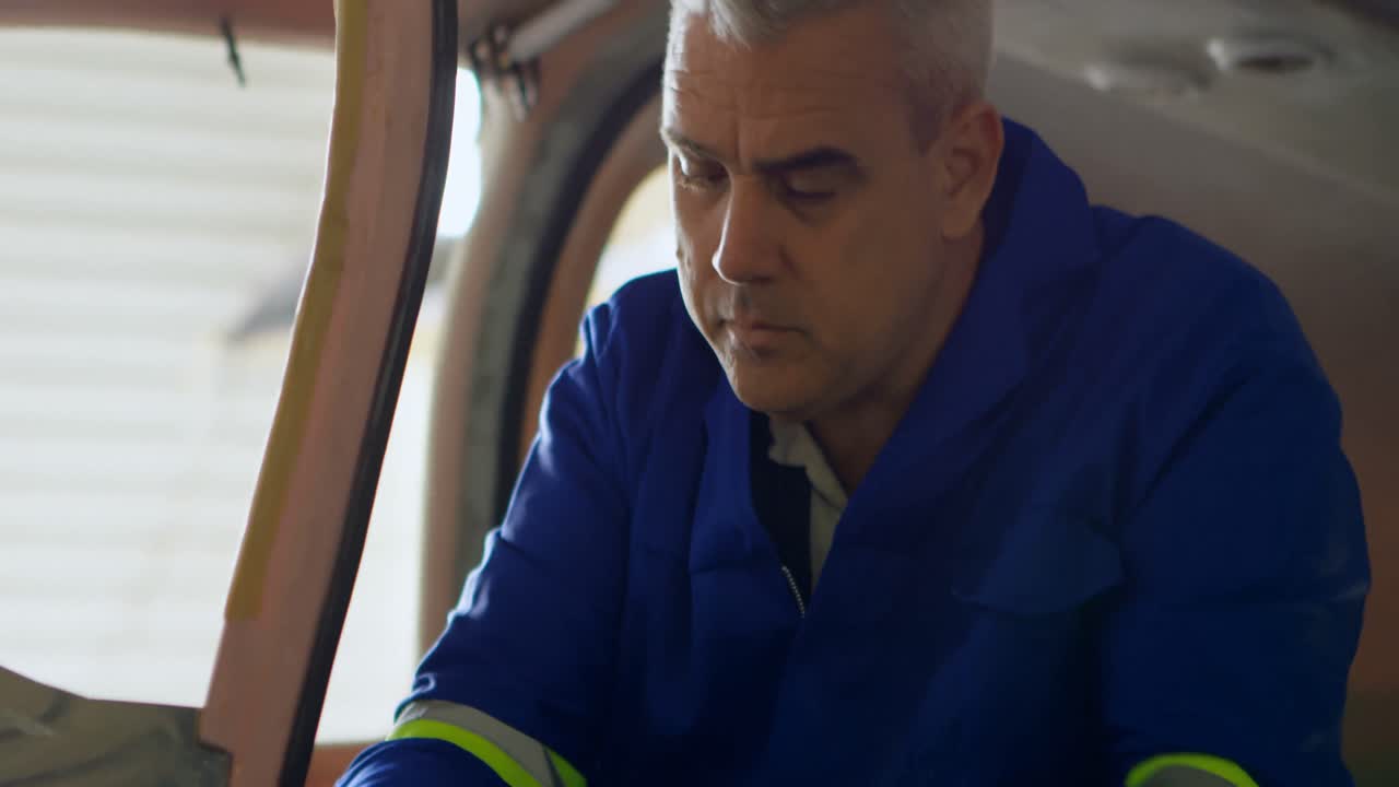 엔지니어가  ⁇ 거 4k에서 항공기를 수리하고 있습니다.