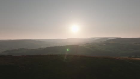 Vuelo-De-Drones-Sobre-Colinas,-Sol-Bajo,-Día-De-Verano-Brumoso,-Campo