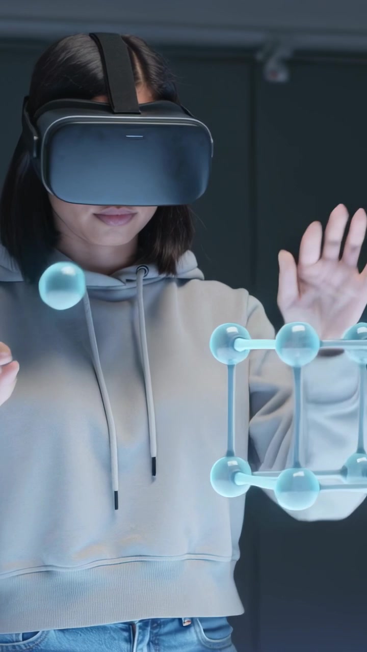 Вертикальное видео: Реагирующая женщина в толстовке и VR-гарнитуре присоединяется к появляющейся 3D-решетке, образующей куб в комнате.