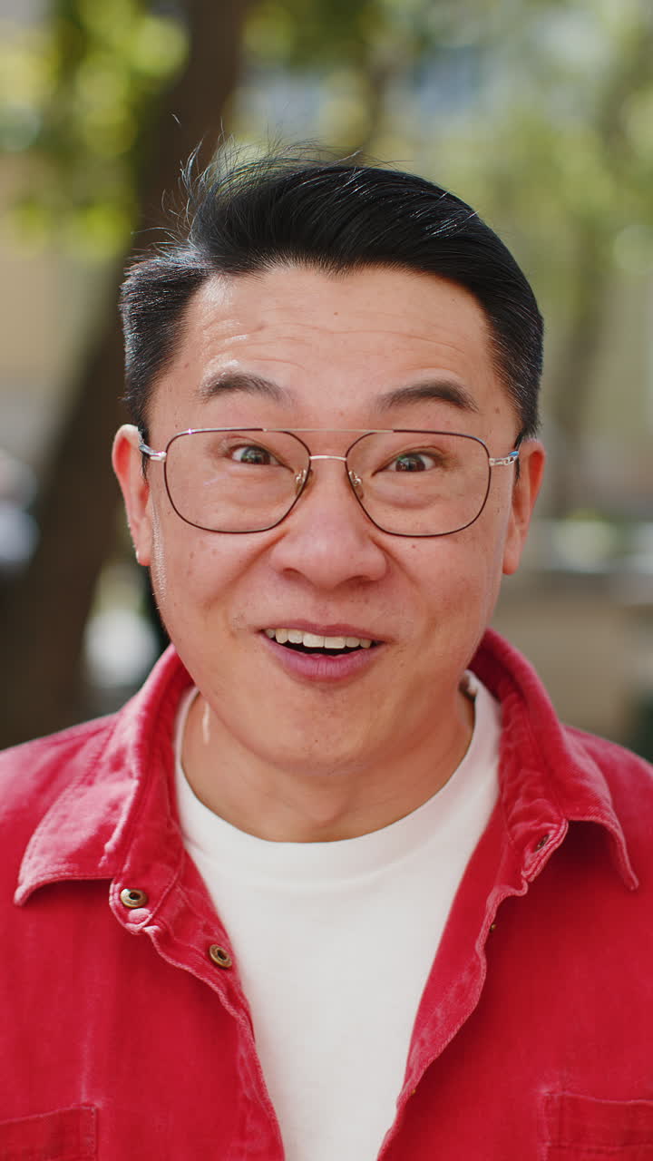 Asian man looking surprised at camera shocked by sudden win good victory news wow in city street