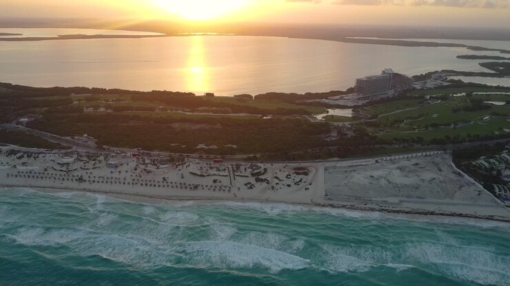 Filmagem de drone do pôr do sol na praia do resort em Cancun, México, revelando imagens aéreas