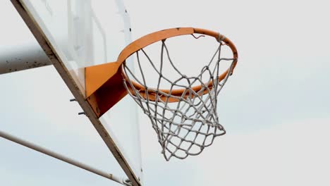 old basketball hoop, ball passes through an old basketball hoop