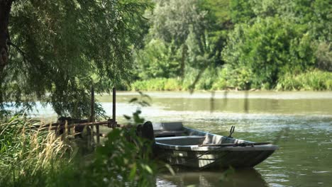 peaceful view of desolated old boat docking on side of slow river