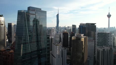 drones aéreos volando sobre el horizonte de kuala lumpur durante la puesta de sol en malasia con vistas a merdeka 118 y la torre kl durante el día