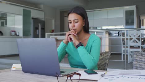 mujer afroamericana usando una computadora portátil mientras trabaja desde casa