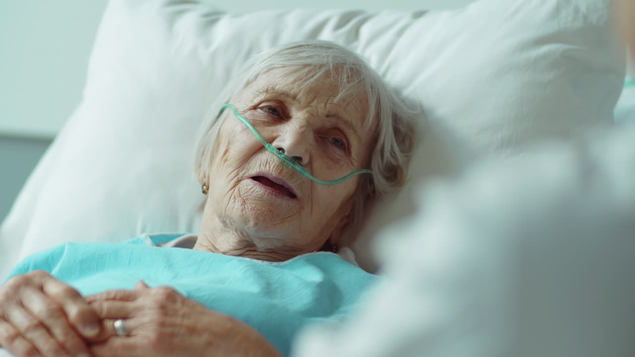 mujer mayor acostada en una cama de hospital y hablando con el médico
