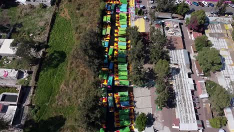 Toma-Aérea-De-Drones-De-Botes-Coloridos-En-Los-Canales-De-Agua-De-Xochimilco-En-Trajineras-Ciudad-De-México-Durante-El-Día