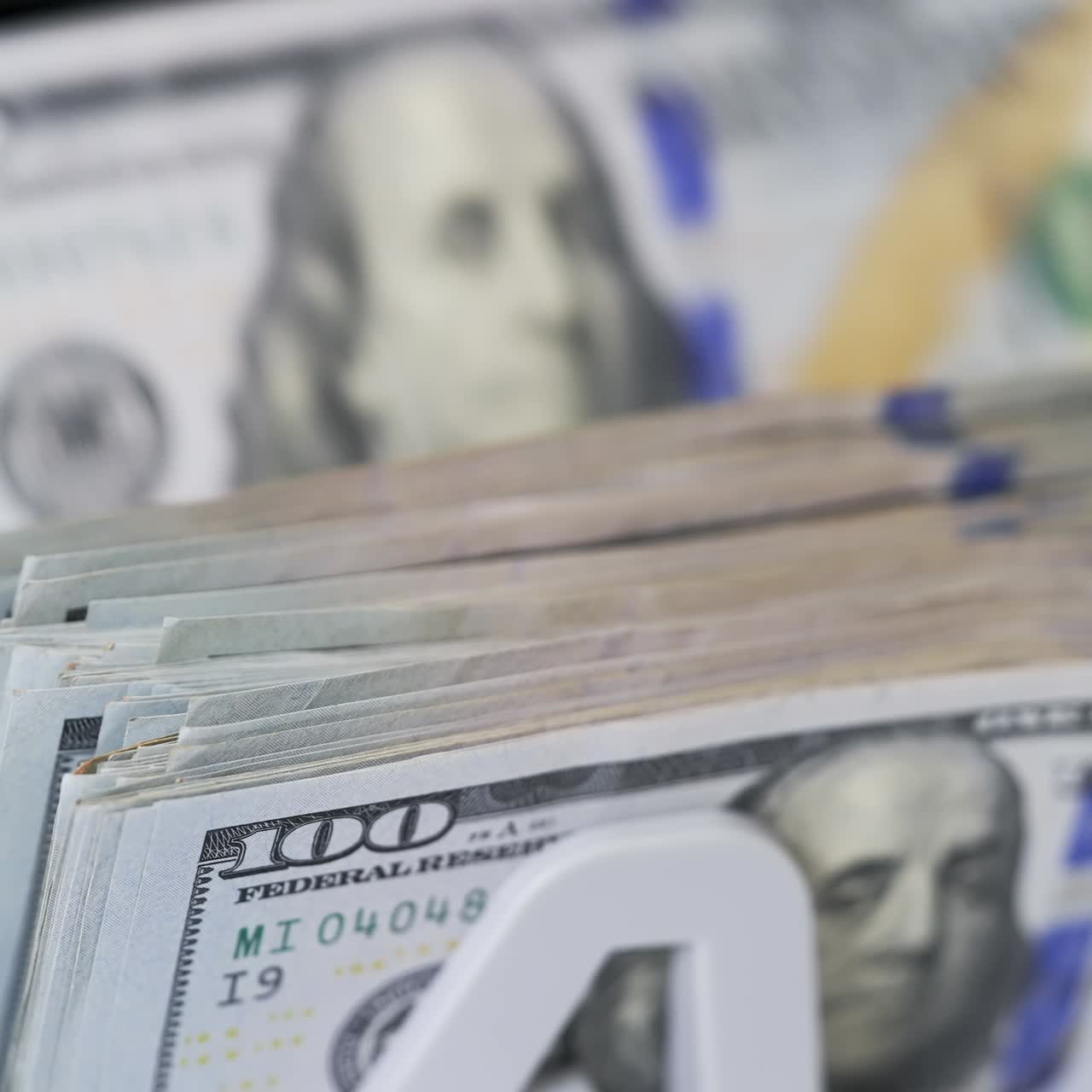 Money counting equipment for paper money calculation. Automatic mechanism for bank financial operations. Female hand taking a bundle of counted dollar bills from counting machine. Close-up