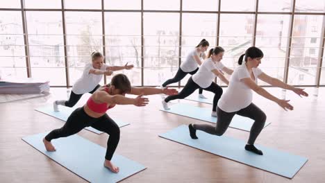 women doing stretching exercises in a modern gym with an instructor