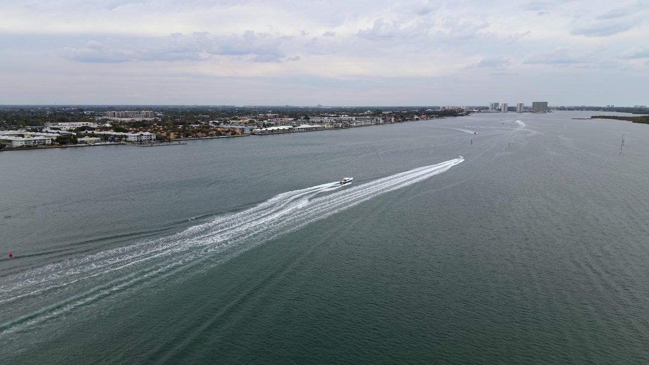 Static drone shot of 2 boats going north on the ICW, Intracoastal Waterway in Riviera Beach Florida near Blue Heron Bridge and Phil Foster Park.