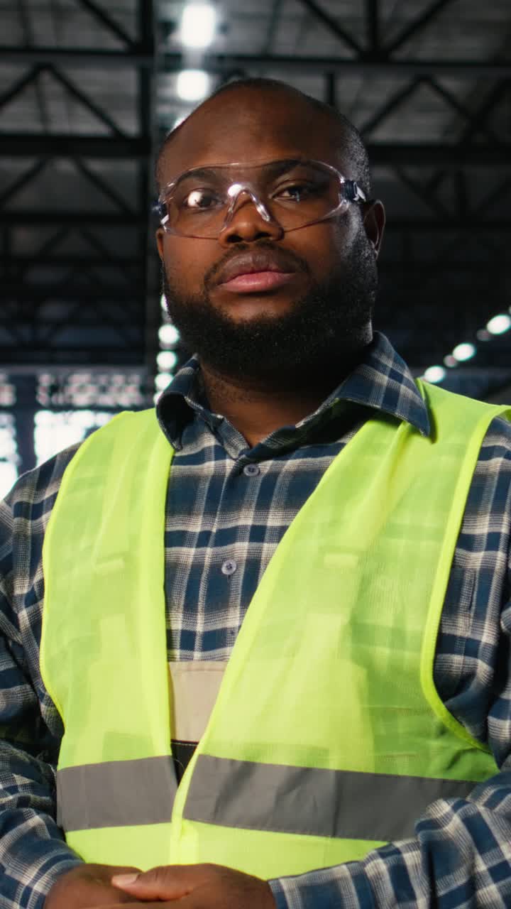 Vertical Video Black worker in a plant overseeing steel manufacturing with automation equipment