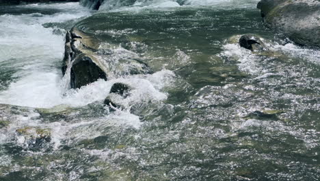 water texture in clear stream in mountain rocks. water current on river rapids.